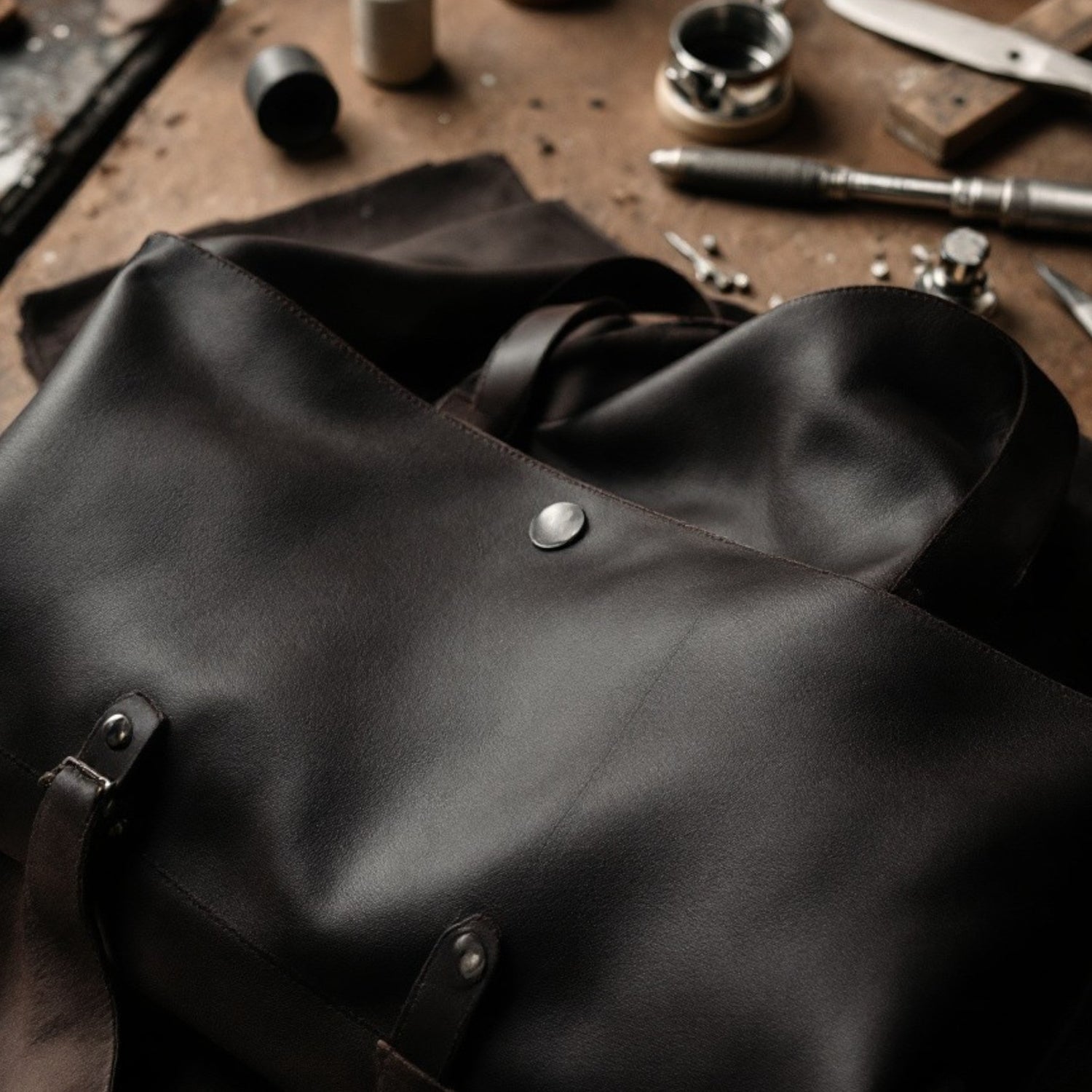Close-up of hand tools and premium leather used to craft Wyoming Jack products