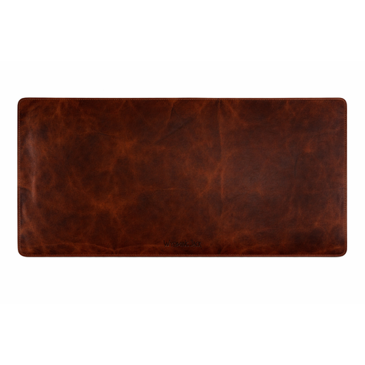 Wyoming Jack Frontier Leather Desk Pad showing a smooth, brown leather surface on a modern office desk.