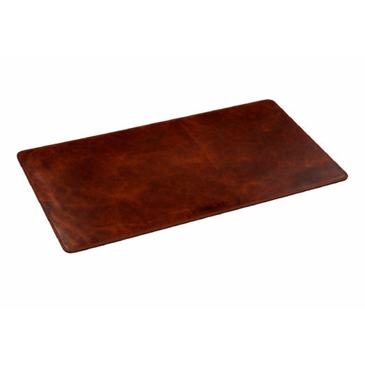 Wyoming Jack Frontier leather desk pad laid flat on a wooden desk, showcasing its smooth, durable leather surface and craftsmanship.