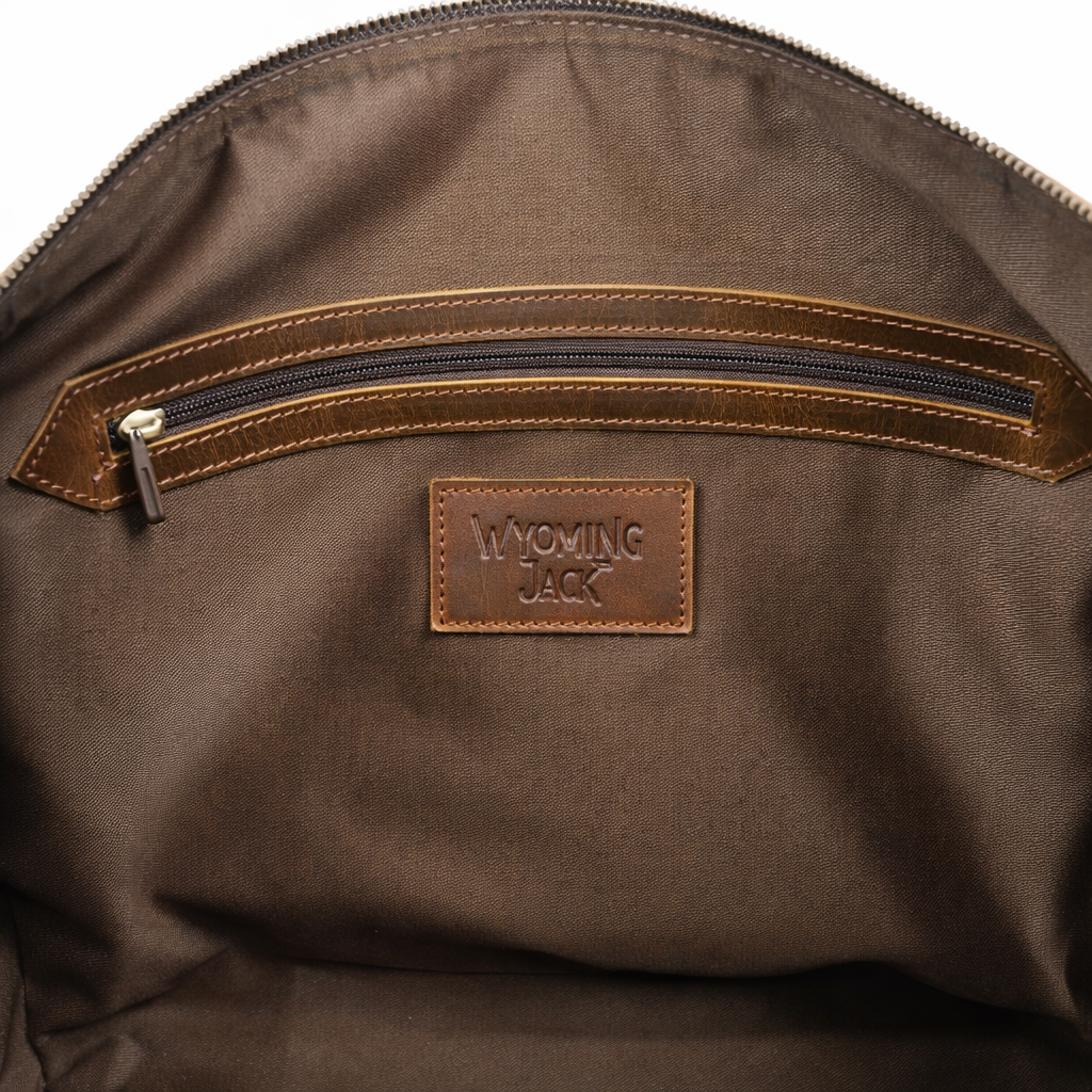 Wyoming Jack Trail Boss leather duffle bag in Brandy color, showing durable leather construction and sturdy handles.