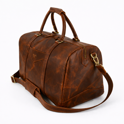 Wyoming Jack Trail Boss leather duffle bag in Brandy color with sturdy handles and leather detailing, diagonal view.