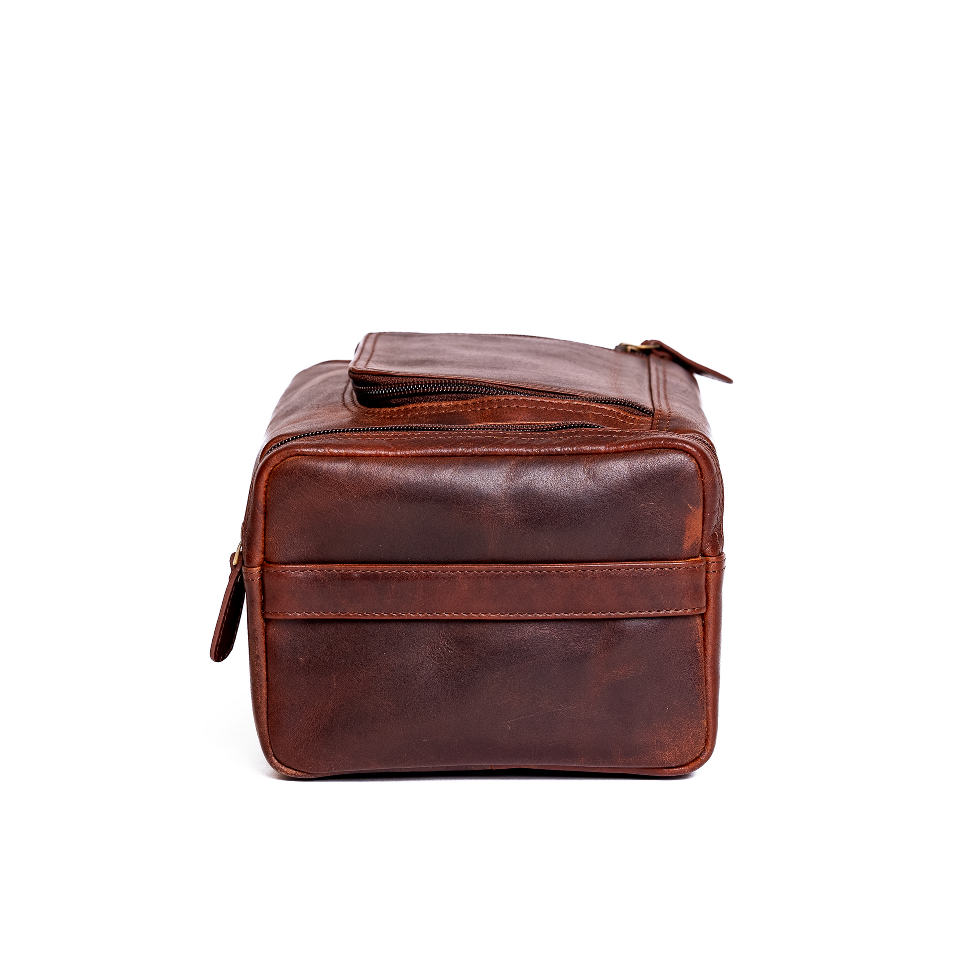 Wyoming Jack Frontier Leather Toiletry Bag for travel, featuring a sleek brown leather design with a zippered closure and handle.